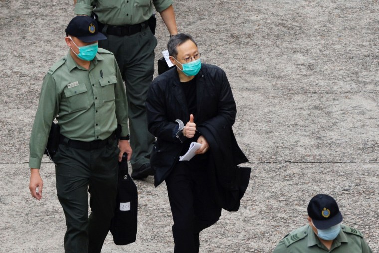 Pro-democracy activist Benny Tai flashes thumbs up as he walks to a prison van to head to court, over the national security law charge, in the early morning, in Hong Kong