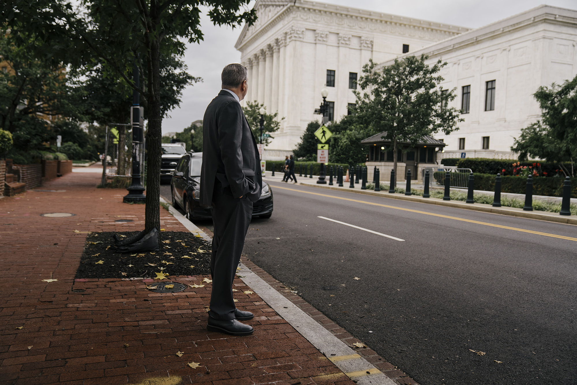 The back view of a man in a suit standing and looking at the Supreme Court building.