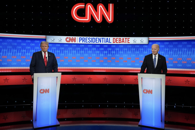 Donald Trump And Joe Biden stand at podiums on a studio set at CNN