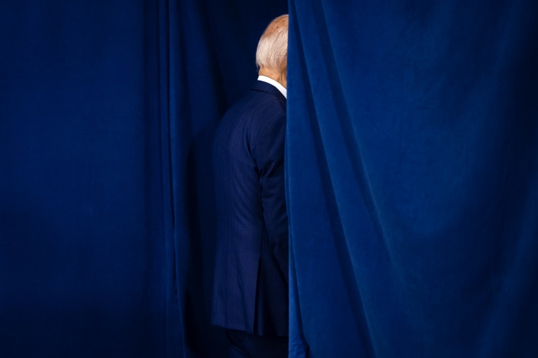 President Biden exits behind a blue curtain