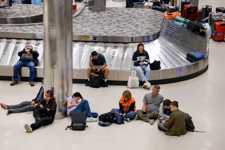 Travelers sit on the floor