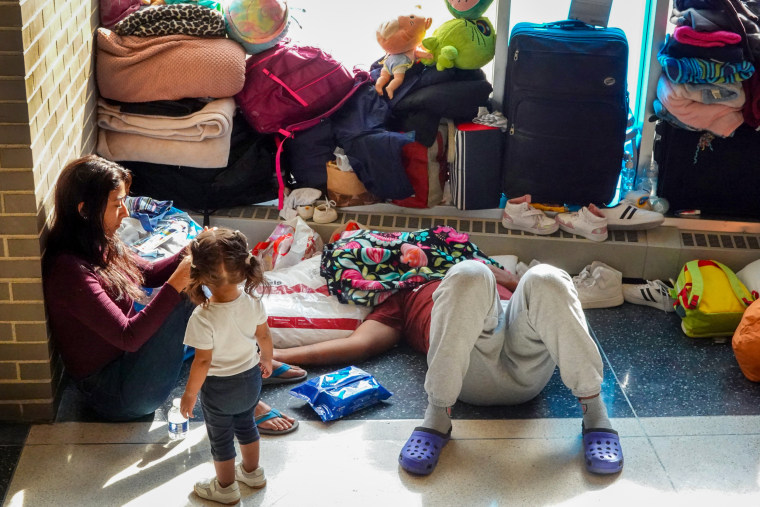 Migrants rest in the floor.