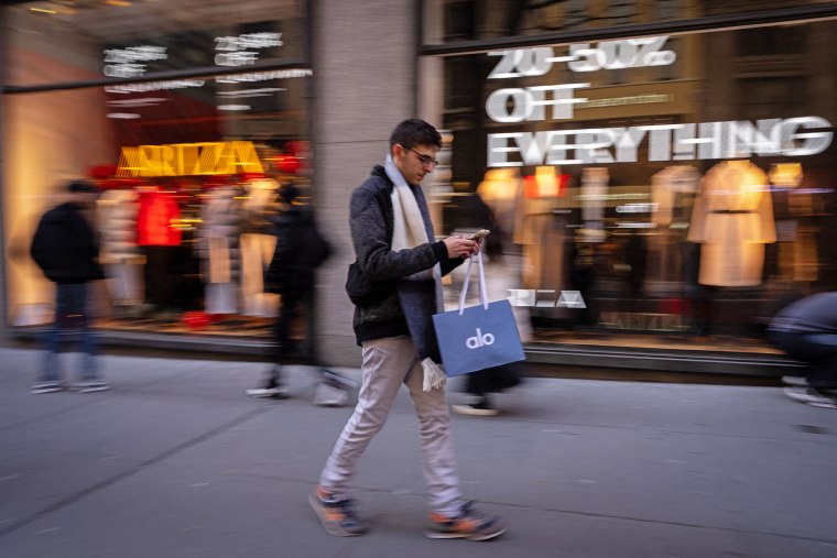 People walk past an Aritzia store on Fifth Avenue on Black Friday, in New York City on November 29, 2024. 