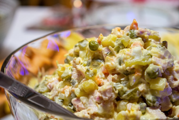 Peas, cubed meat, potatoes, and mayonnaise in a clear bowl