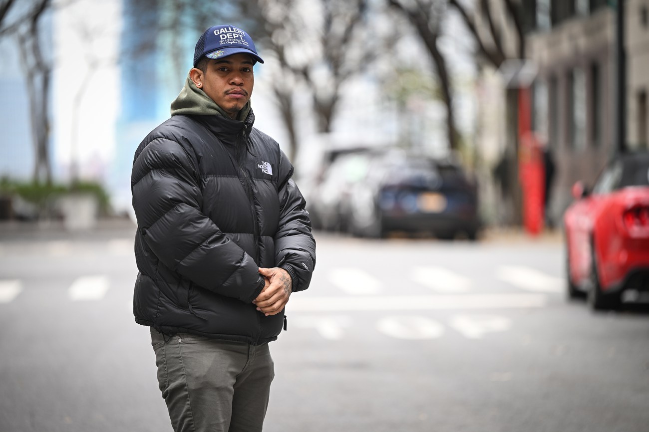 Portrait of a man with a black jacket, standing in the street.