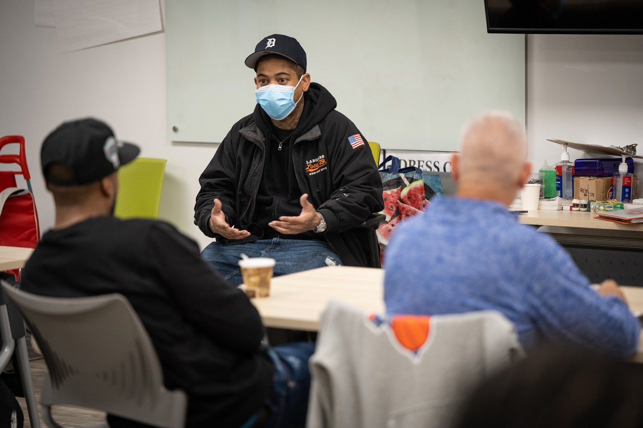 Man wearing a mask facing students in a classroom.