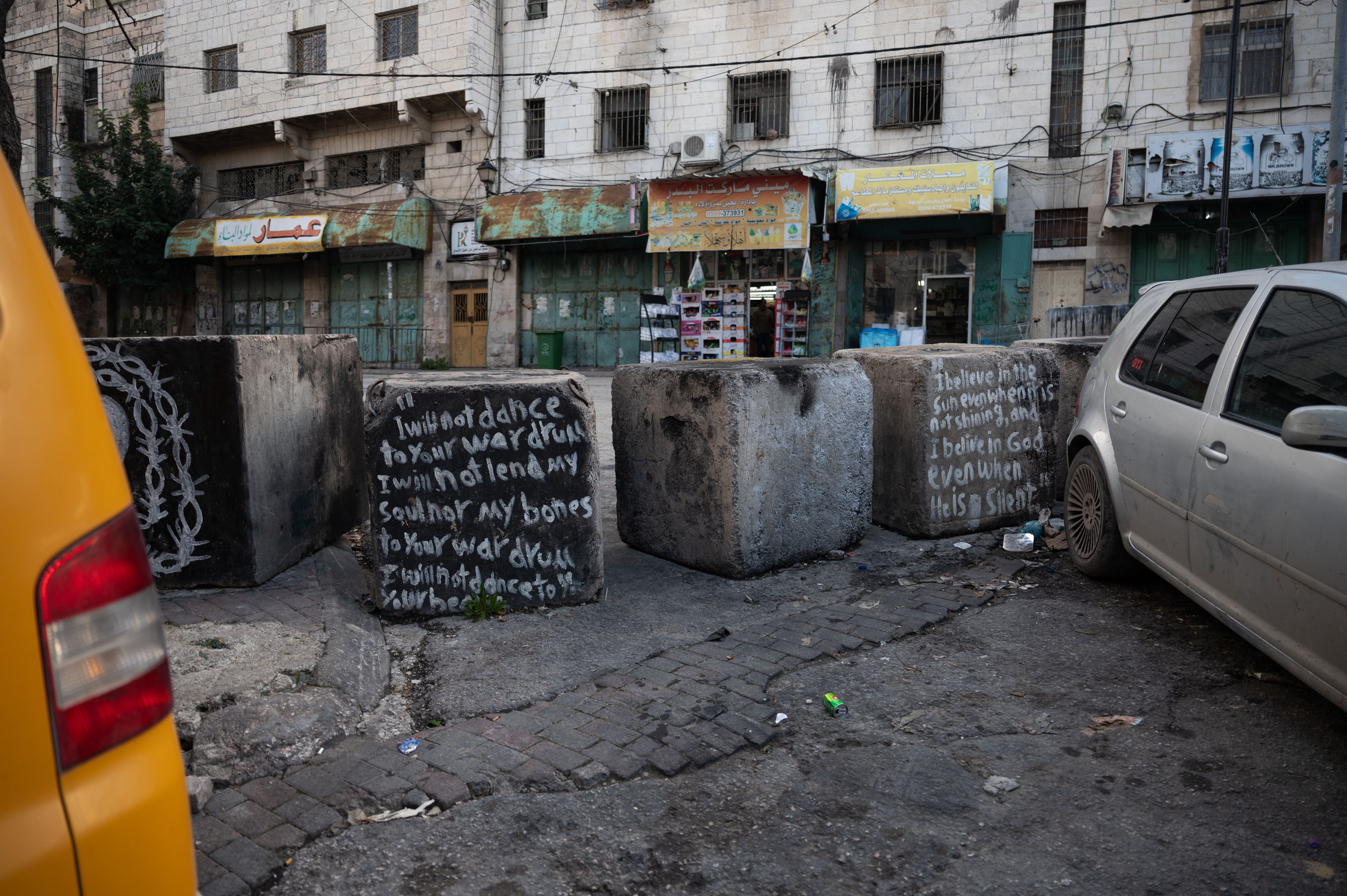 Concrete blocks in a street with grafitti on them.