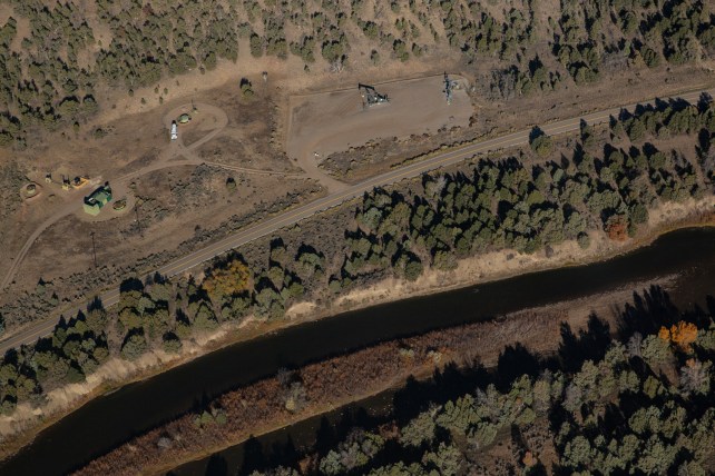 A bird's eye view of a river, the edges speckled with dark green trees.