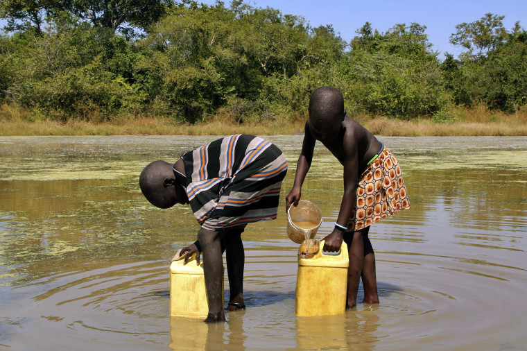 In this Nov. 4, 2010 photo, children collect drinking water from a pond using filters provided to them by The Carter Center’s guinea worm eradication program in the remote village of Lengjak, in Awerial County, Lakes State, Southern Sudan. 