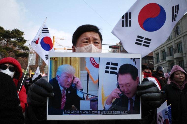 A supporter of South Korean president Yoon Suk Yeol holds a placard of Yoon and incoming US president Donald Trump that translates as "He responded by sending his special regards to the people of South Korea", during a rally near his residence in Seoul on January 6, 2025.