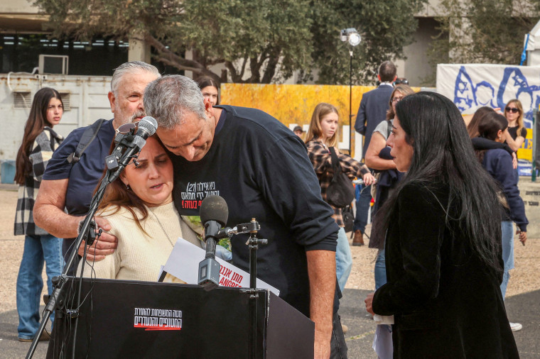 Family members of Israeli hostages comfort each other.