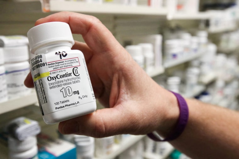 A pharmacist holds a bottle OxyContin