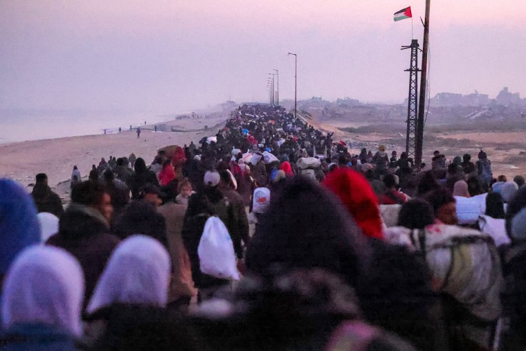 Displaced Palestinians walk along Gaza's coastal al-Rashid Street in Nuseirat towards the Netzarim corridor to cross to the northern part of the Gaza Strip 