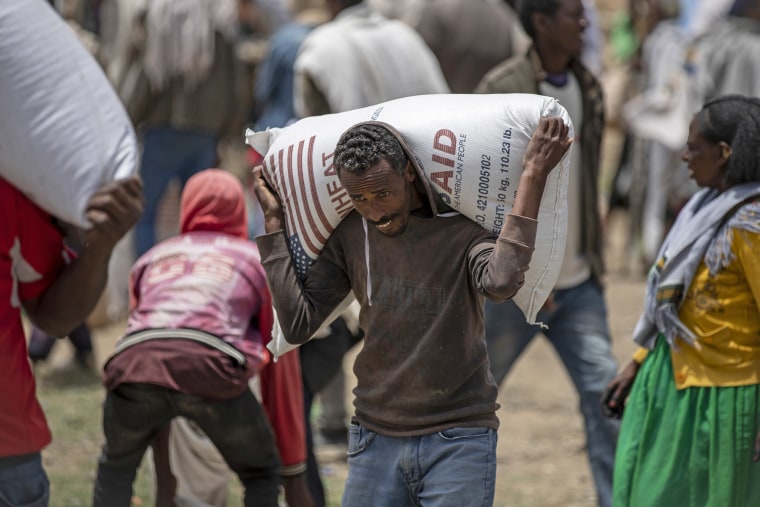 An Ethiopian man carries a sack of USAID wheat in northern Ethiopia in 2021.