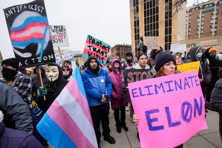 People hold up signs during a protest outside the Wisconsin Capitol