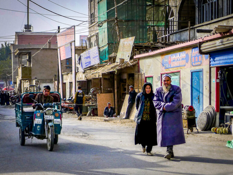 An older uyghur man and woman walk along a street in Yarkant near Kashgar in the Xinjiang Uygur Autonomous Region of western China