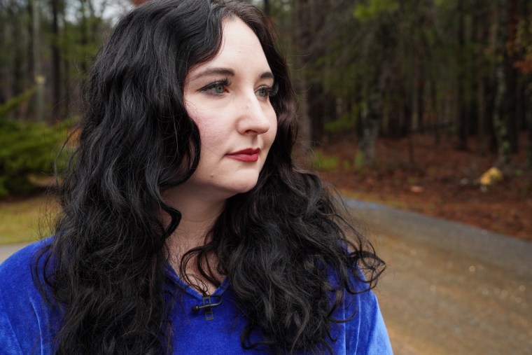 Aileen Reneau stands outside in a forest area for a portrait